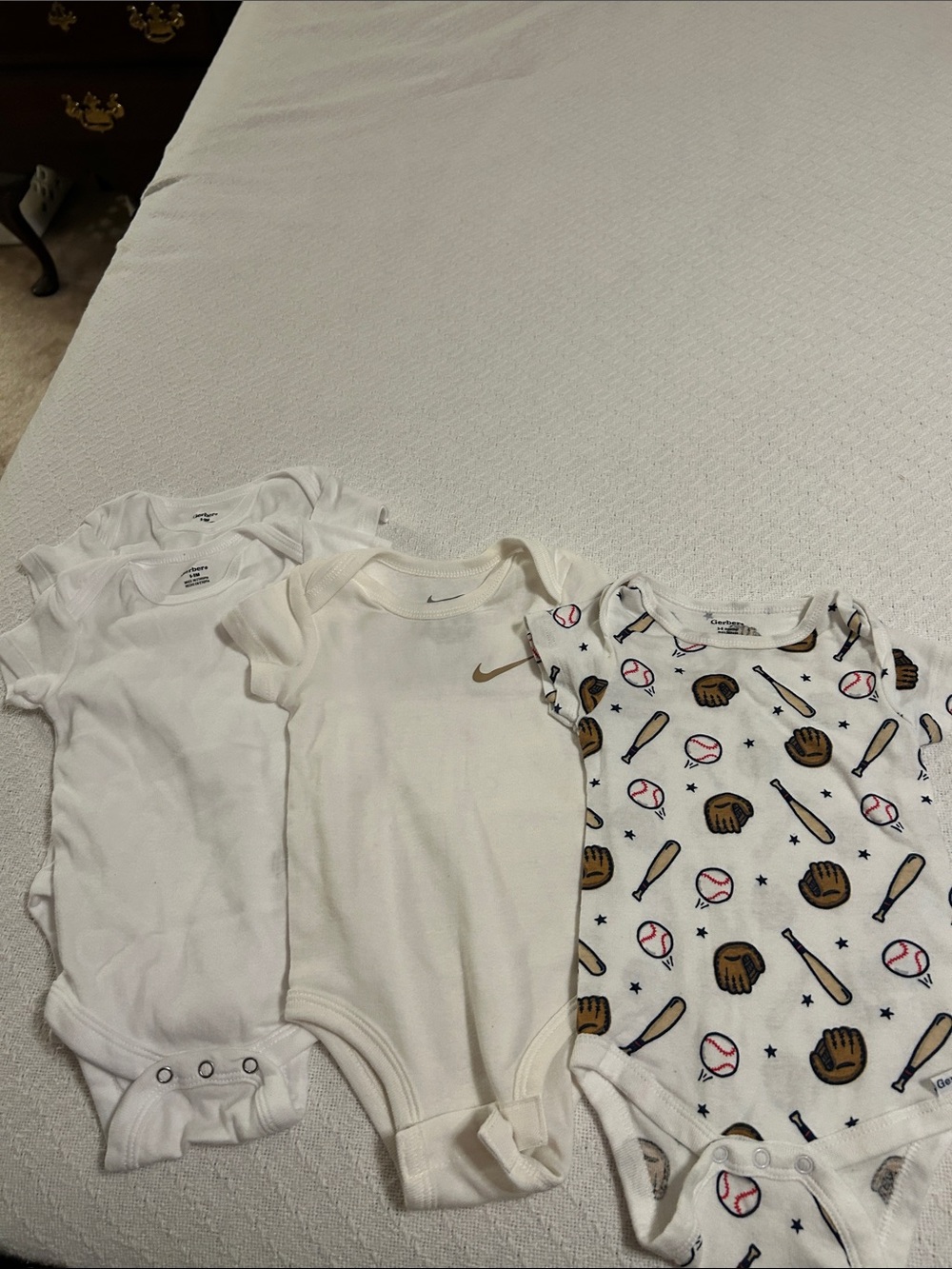 4 onesies , 3 Gerber brand and 1 Nike  White & Cream.  3-6 and 6-9 months